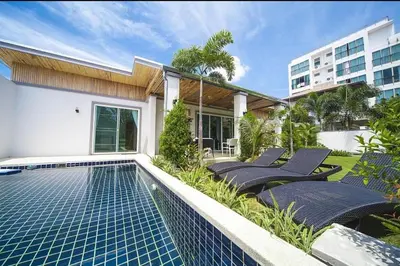 a swimming pool with lounge chairs next to a building at Villa with private pool in Kamala in Kamala Beach