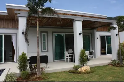 a house with a porch with a table and chairs at Villa with private pool in Kamala in Kamala Beach