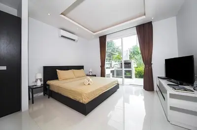 a bedroom with a bed and a television in a room at Villa with private pool in Kamala in Kamala Beach