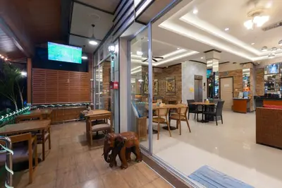 a restaurant with tables and chairs and a dog statue at Baan KetKaew Patong in Patong Beach