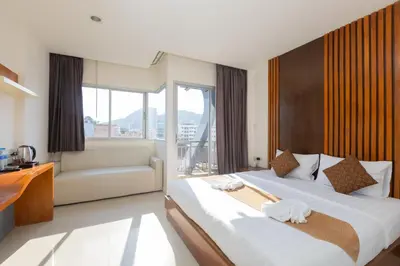 a hotel room with two beds and a couch at Baan KetKaew Patong in Patong Beach