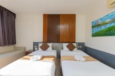 a room with two beds and a couch at Baan KetKaew Patong in Patong Beach