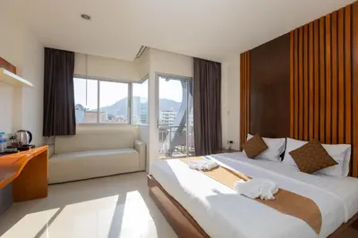 a hotel room with two beds and a couch at Baan KetKaew Patong in Patong Beach