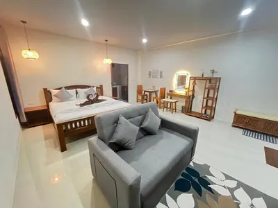 a bedroom with a bed and a couch in a room at The wells house krabi in Klong Muang Beach