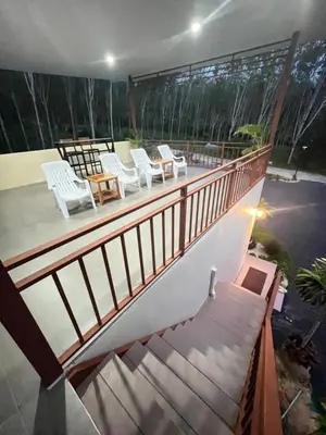 a balcony with white chairs and a table at The wells house krabi in Klong Muang Beach