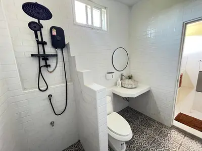 a bathroom with a shower and a toilet and a sink at The wells house krabi in Klong Muang Beach