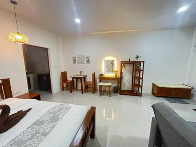 a bedroom with a bed and a dining room at The wells house krabi in Klong Muang Beach