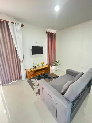 a living room with a couch and a television at The wells house krabi in Klong Muang Beach