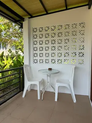 a white table and two chairs on a balcony at Sea Escape Koh Yao Yai in Ko Yao Yai
