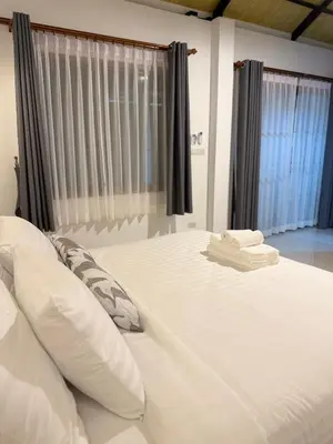 a bed with white sheets and pillows in a bedroom at Sea Escape Koh Yao Yai in Ko Yao Yai
