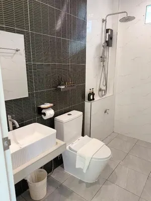 a white bathroom with a toilet and a sink at Sea Escape Koh Yao Yai in Ko Yao Yai