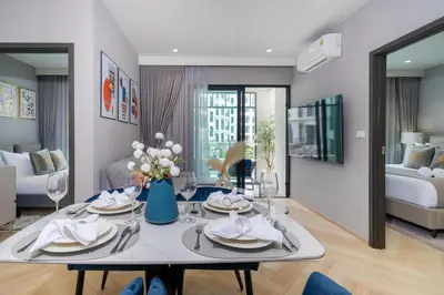 a dining room and living room with a table and chairs at The Title Legendary Condo with a large terrace 308 in Bang Tao Beach