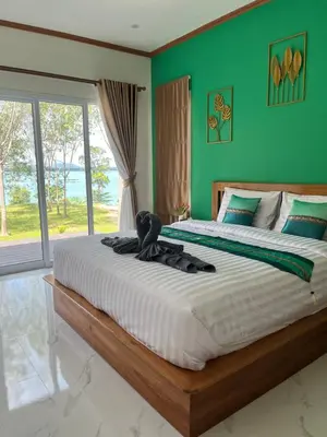 a large bed in a bedroom with a green wall at SeaMountain Kohyao Noi in Ko Yao Noi