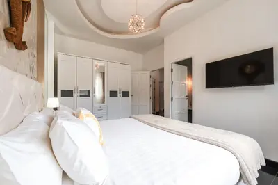 a bedroom with a white bed with a tv on the wall at Platinum Villa Rawai 76 in Rawai Beach