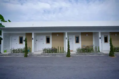 a building with white doors and some plants at The Cozy Haus Airport in Ban Muang Mai (1)