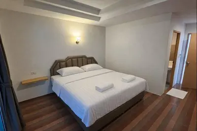 a bedroom with a large bed with two towels on it at HUG PHIPHI Resort in Phi Phi Don