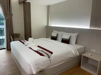 a bedroom with a large bed with white sheets and pillows at Salty Sand Krabi Hotel in Ban Khlong Haeng