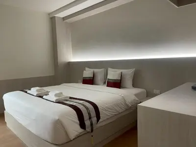 a bedroom with two beds with white sheets and red pillows at Salty Sand Krabi Hotel in Ban Khlong Haeng