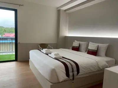 a large white bed in a room with a window at Salty Sand Krabi Hotel in Ban Khlong Haeng