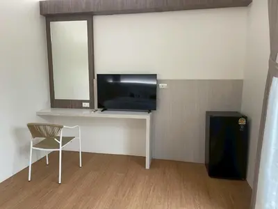a room with a desk with a television and a chair at Salty Sand Krabi Hotel in Ban Khlong Haeng