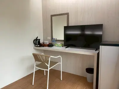 a room with a chair and a flat screen tv at Salty Sand Krabi Hotel in Ban Khlong Haeng