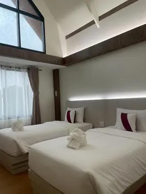 a hotel room with two beds and a window at Salty Sand Krabi Hotel in Ban Khlong Haeng