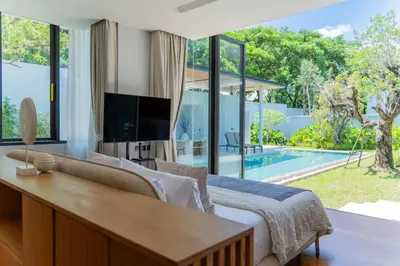 a bedroom with a bed and a tv and a pool at UltraLuxury 4BDR pool villa Botanica Foresta in Ban Phru Champa