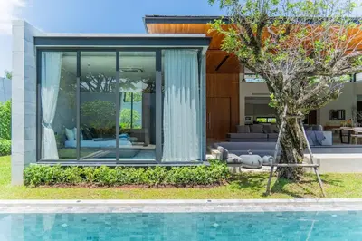 a house with a swimming pool and a tree at UltraLuxury 4BDR pool villa Botanica Foresta in Ban Phru Champa