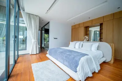 a bedroom with a large white bed and glass doors at UltraLuxury 4BDR pool villa Botanica Foresta in Ban Phru Champa