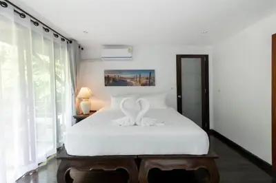 a bedroom with a bed with two swans on it at Beautiful Patong Sea View 6 Bedroom Thai Luxury Villa Near Bar Street, Jungceylon in Patong Beach