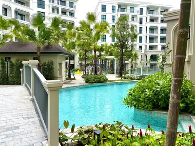 a swimming pool with palm trees and buildings at The Legendary Bang Tao 2-bedrooms apart #701 in Bang Tao Beach