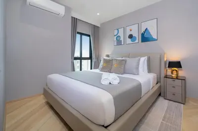 a white bedroom with a large white bed and a window at The Legendary Bang Tao 2-bedrooms apart #701 in Bang Tao Beach