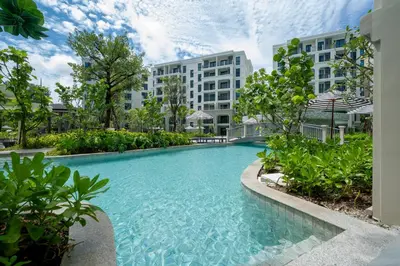 a swimming pool in front of some buildings at Apartments 15 minutes walk from Bangtao Beach with a cinema in Phuket