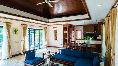 a living room with a blue couch and a dining room at Genesis Elephant Villa in Rawai Beach