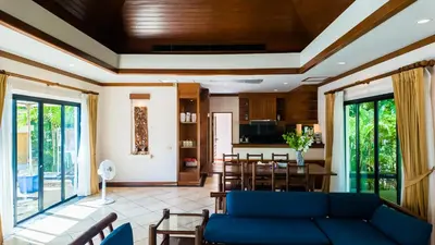 a living room with a blue couch and a table at Genesis Elephant Villa in Rawai Beach