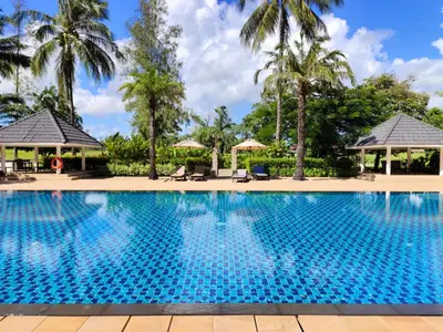a swimming pool at a resort with palm trees at Apartment 2 bedrooms in Allamanda in Laguna Phuket