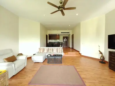 a living room with a couch and a ceiling fan at Apartment 2 bedrooms in Allamanda in Laguna Phuket