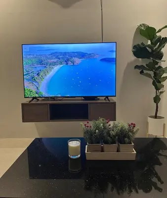 a flat screen tv sitting on a stand with potted plants at The Viva Patong Sea view and Mountain views in Patong Beach