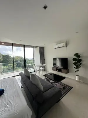 a white living room with a couch and a tv at The Viva Patong Sea view and Mountain views in Patong Beach
