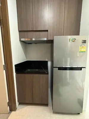 a kitchen with a stainless steel refrigerator and wooden cabinets at The Viva Patong Sea view and Mountain views in Patong Beach