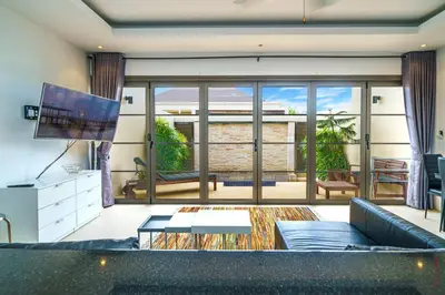 a living room with a couch and a tv at The Residence One-Bedroom Villa in Ban Thalat Choeng Thale