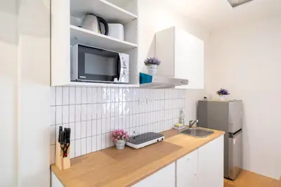 a kitchen with a counter with a sink and a refrigerator at Cozy Home in heart of Patong in Patong Beach