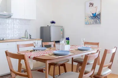 a kitchen with a wooden table with chairs and a dining room at Cozy Home in heart of Patong in Patong Beach