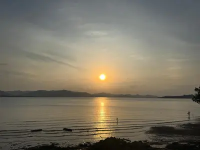 a sunset over the water with the sun in the sky at The Good View Koh Yao Noi in Ko Yao Noi