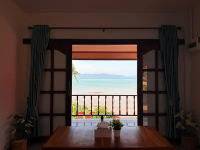 a room with a table and a view of the ocean at The Good View Koh Yao Noi in Ko Yao Noi