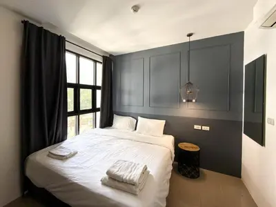 a bedroom with a bed with two towels on it at Palmyrah Surin Apartments by Mill in Surin Beach