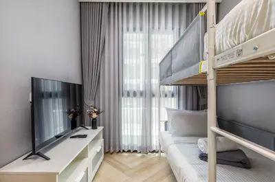 a bedroom with a bunk bed and a television at Family Deluxe close to Bang Tao Beach in Bang Tao Beach