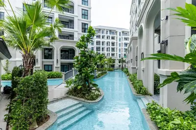 an infinity pool in the middle of a building with palm trees at Family Deluxe close to Bang Tao Beach in Bang Tao Beach