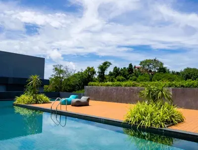 a swimming pool with a couch and chairs next to a building at Pool Access 1 Bedroom Duplex UTL A107 near Nai Harn Beach in Rawai Beach