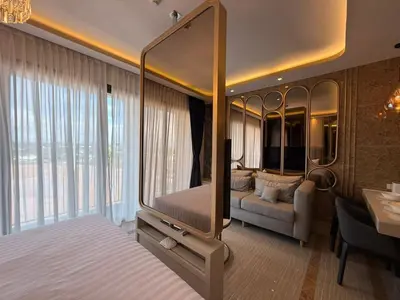 a bedroom with a bed and a couch in a room at New Studio in Bellevue Lagoon Phuket in Laguna Phuket